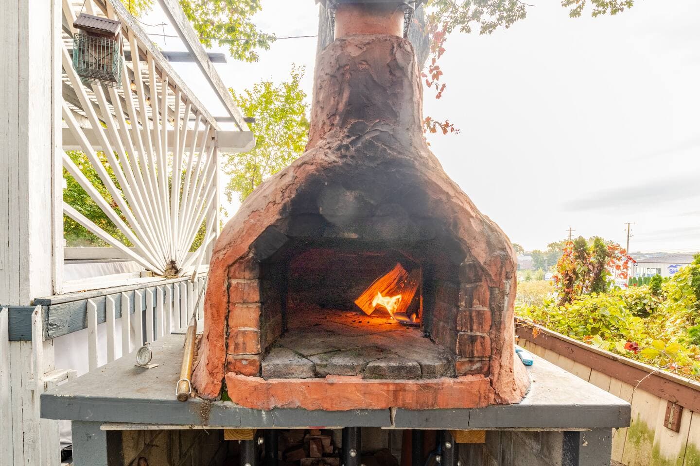 Wood-fired brick pizza oven with a live fire